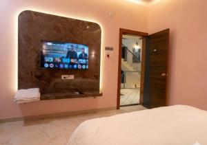 a bedroom with a flat screen tv on a wall at Raj Royal Hotel in Nagpur +16 photos