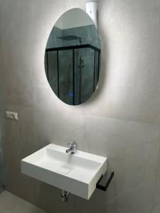 a bathroom with a white sink and a mirror at Sa Domo Bonaria - Intero appartamento in Osilo