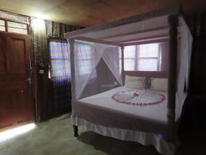 a bedroom with a bed with a canopy at Drifters Zanzibar in Paje
