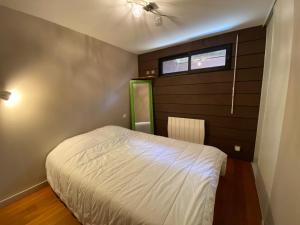 a small bedroom with a bed and a window at BELLEVUE Maison Atypique Grande Terrasse au Calme in Pyla-sur-Mer