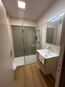 ein Badezimmer mit Dusche und Waschbecken in der Unterkunft Hotel les Alignements in Carnac + 50 Fotos