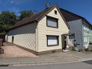 a white and black house with two windows at Ferienhaus Weitblick in Oberthal