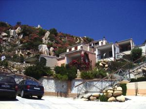 a house on a hill with cars parked in front of it at Apartment in Costa Rei with Stunning Sea View in Costa Rei