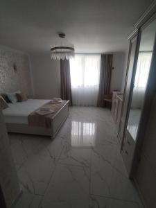 a bedroom with a bed and a large marble floor at Vila Cristal in Arefu