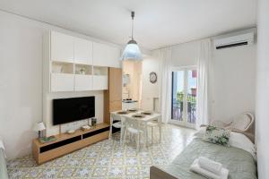 a living room with a bed a desk and a television at Casa Tina in Sorrento