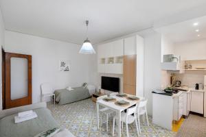a living room with a small table and a kitchen at Casa Tina in Sorrento