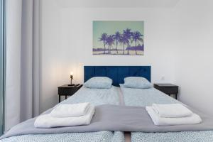 a bedroom with a bed with two towels on it at Apartamenty pod Modrzewiem in Ustronie Morskie +136 photos