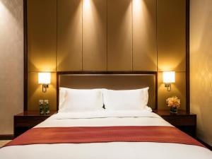um quarto com uma grande cama branca e 2 candeeiros em Holiday Inn Beijing Airport Zone, an IHG Hotel em Shunyi