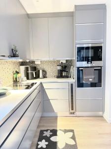 a white kitchen with white cabinets and appliances at Solbacken 59 in Landvetter