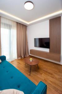 a living room with a blue couch and a table at Lastva Cozy apartment in Prijevor