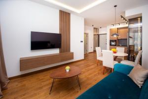 a living room with a blue couch and a table at Lastva Cozy apartment in Prijevor