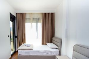 a bedroom with two beds and a window at Lastva Cozy apartment in Prijevor