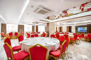 a banquet hall with tables and red chairs at Royal Mark Hotel in Sylhet