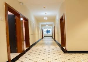 an empty hallway with doors and a tile floor at Raj Royal Hotel in Nagpur