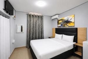 a bedroom with a bed and a tv at Hotel Metro Lodge Beach in Durban +38 photos