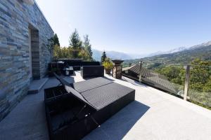 a balcony of a house with a view of the mountains at Villa moderne avec Jacuzzi - ski - golf in Icogne