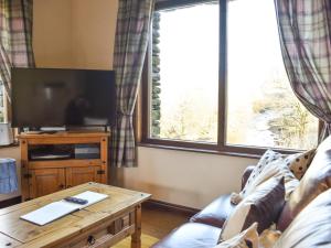 a living room with a couch and a large window at River View Cottage-Uk42226 in Low Borrowbridge