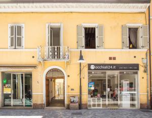 a yellow building with windows and a balcony at Dimora RAVENNA CORTE CHARME Diaz in Ravenna