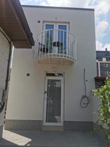 a white house with a balcony and a door at Happy Home2 in Cahul