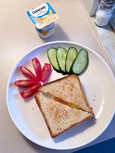 a sandwich and vegetables on a white plate at Gatto in Bishkek +1 photo