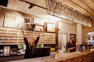 a woman with her hands in the air in a restaurant at Wombat's City Hostel Munich Hauptbahnhof in Munich +31 photos