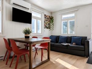 a living room with a couch and a table and chairs at Chic Shack with spa - near Massif Charlevoix & MSA in Saint-Tite-des-Caps
