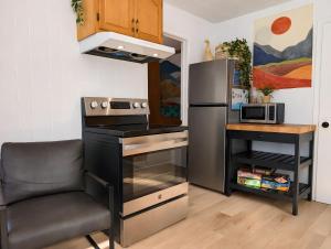 a kitchen with a stove and a refrigerator at Chic Shack with spa - near Massif Charlevoix & MSA in Saint-Tite-des-Caps