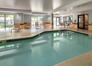 a large swimming pool in a building with tables and chairs at SpringHill Suites Pittsburgh Mills in Tarentum
