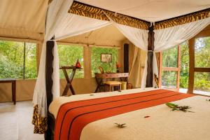 a bedroom with a bed in a tent at Exploreans Mara River Camp in Musiara Campsite