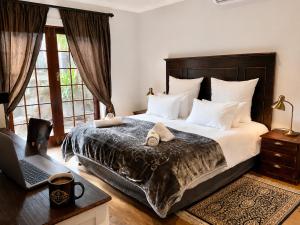 a bedroom with a bed and a laptop on a desk at Goblin's Mead in Edgemead +70 photos