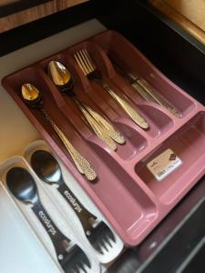 a group of utensils sitting on a pink tray at Aisi in Jut'a