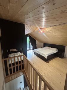 a room with a bed and a wooden staircase at Forest Edge in Borjomi