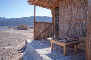 a table sitting outside of a hut on the beach at Eden Camp Abu Galum in Dahab +31 photos