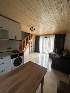 a kitchen and living room with a couch and a table at Forest Edge in Borjomi