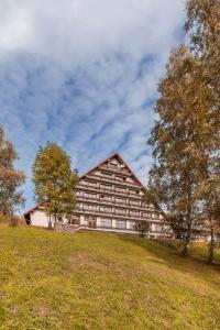 un grande edificio che sorge sopra un campo erboso di Hotel Rusava a Rusava