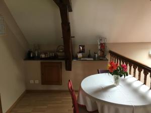 a dining room table with a vase of flowers on it at Chambres d'hôtes Arcelot in Arceau +7 photos