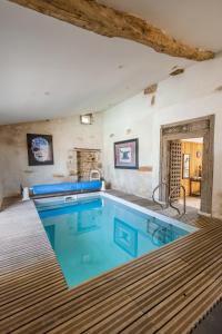 a large swimming pool with blue water in a room at Maison Lotus - Groupes et familles, séjour Nature au coeur du Périgord Vert in Saint-Martial-de-Valette +12 photos