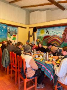 a group of people sitting at a table eating at Hospedaje Vista Ausangate in Labramarca