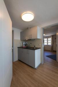 an empty kitchen with white cabinets in a room at FeWo-Dierhagen in Prerow +10 photos