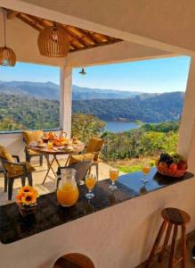 a porch with a table with glasses of orange juice at Pousada altavista acuruí in Itabirito