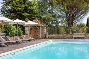 a swimming pool with lounge chairs and umbrellas at Maison Lotus - Groupes et familles, séjour Nature au coeur du Périgord Vert in Saint-Martial-de-Valette