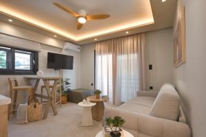 a living room with a couch and a ceiling fan at Sea Salt Skiathos in Skiathos