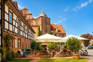a group of people sitting at tables outside a building at Hotel Vorderburg in Schlitz
