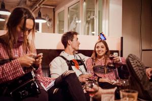 a group of people sitting in a room looking at their cell phones at Wombat's City Hostel Munich Hauptbahnhof in Munich