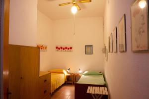 a small bedroom with a bed and a ceiling fan at Casa Zolesiop in SantʼAnna Arresi