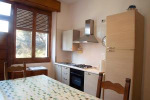 a kitchen with a table and a stove top oven at Casa Zolesiop in SantʼAnna Arresi +6 photos