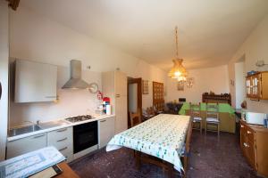 a kitchen with a table and a dining room at Casa Zolesiop in SantʼAnna Arresi