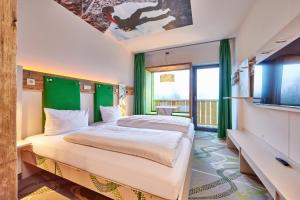 a bedroom with a large bed and a tv at Explorer Hotel Bayrischzell in Bayrischzell +17 photos