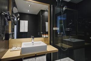 a bathroom with a sink and a shower at NH Berlin Potsdamer Platz in Berlin