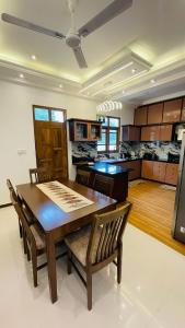a kitchen and dining room with a wooden table and chairs at Harbour Front Villa in Trincomalee